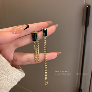 Asymmetric gold chain drop earrings with emerald green rectangular glass stones