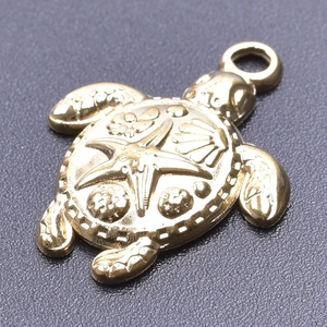 Macro detail of golden turtle pendant with starfish and shell embossed patterns