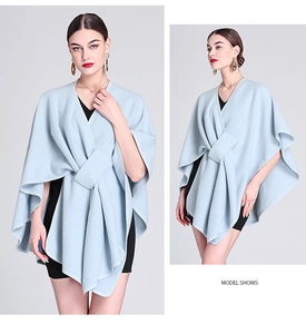Close-up of light blue knit poncho wrap featuring an elegant front knot and soft texture