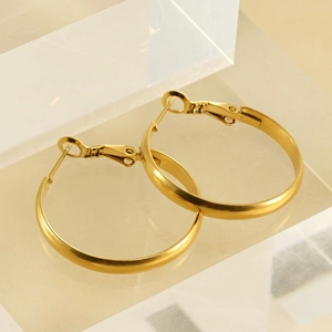 Minimalist gold hoop earrings with matte finish and secure clasp on acrylic stand