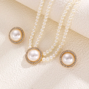 Detailed macro view of French vintage pearl necklace set with gold pendant and earrings