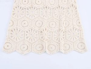 Détail de la jupe en crochet beige avec dentelle florale ajourée et texture tricotée