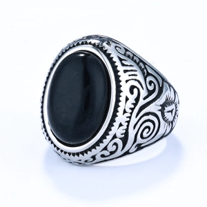 Detailed view of vintage silver ring with black oval stone and side carvings