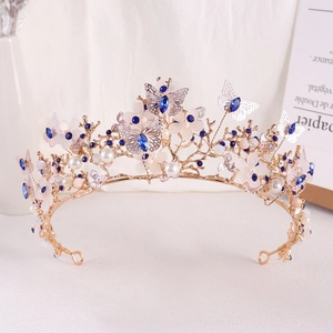 Detailed view of golden bridal tiara featuring blue crystals and filigree butterflies