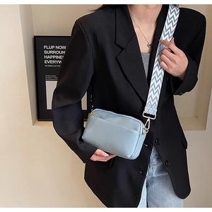 Blue PU leather crossbody bag with blue and white wavy strap detail and golden hardware