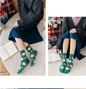 Close-up of green Christmas socks with Santa Claus patterns and ribbed elastic cuffs