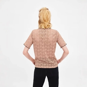 Elegante top in pizzo albicocca con bordi neri a contrasto e maniche corte da donna