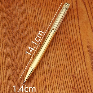 Bamboo shaped vintage brass metal business pen in gold finish on wood desk surface