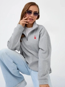 Detail of half-zip stand collar and red heart embroidery on gray cotton sweatshirt