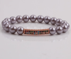Détail du bracelet en perles lavande avec barre en or rose et zircons sur miroir