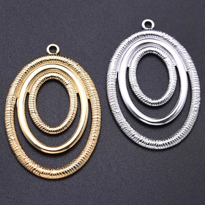 Close-up of irregular textured oval pendants in gold and silver stainless steel