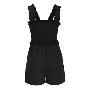 Detail view of black smocked romper showing ruffle trim and elastic bodice texture