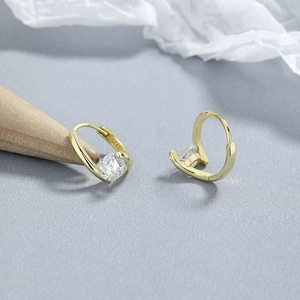 Elegant 925 sterling silver gold hoop earrings with round zircon stones on a gray surface