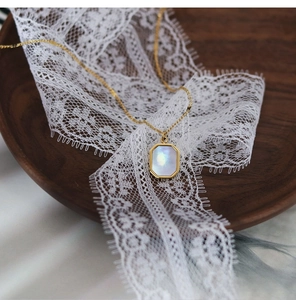 Detailed macro of a hexagonal white shell pendant with 18K gold plated titanium chain