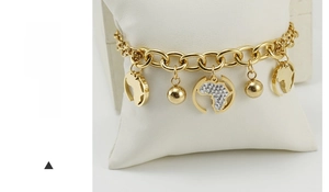 Détail du bracelet carte en or 18 carats avec strass étincelants sur coussin bijoux