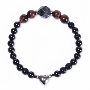 Detail of 6mm black magnetic beaded bracelet with heart charm and tiger eye stones
