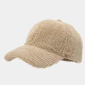 Détail rapproché de la texture douce en fausse fourrure sur une casquette d'hiver beige
