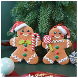 Detail of gingerbread man Christmas ornaments with candy canes hanging on a festive tree