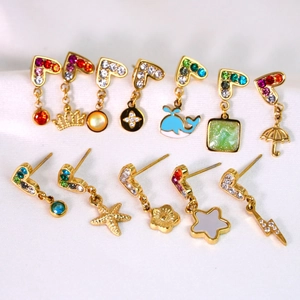 Macro shot of colorful rhinestone heart, crown, and starfish gold earrings set