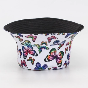 Detalle de gorro de pescador reversible con estampado de mariposas en lona blanca