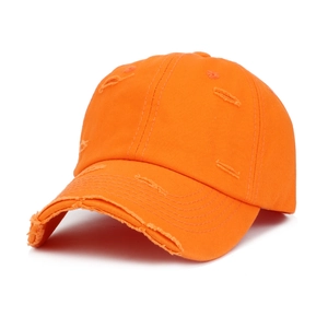 Detailed view of heavy distressing and ripped holes on an orange cotton baseball cap