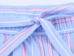 Detailed macro view of elastic waistband with drawstring bow on blue striped pants