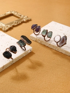 Detail of vintage copper adjustable rings with diverse natural gemstones on stone bases