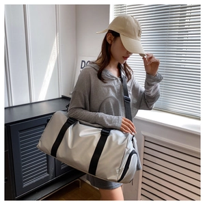 Spacious silver fitness bag with adjustable shoulder strap shown on a model
