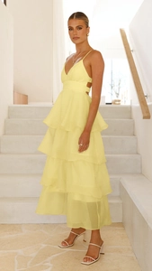 Close-up of four-layer tiered chiffon ruffle hem on a yellow backless cocktail dress