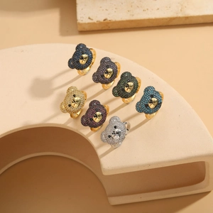 Detailed close-up of seven assorted colorful cubic zirconia bear head rings on a stand
