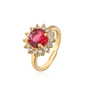 Macro shot of gold-plated flower ring with red gemstone and cubic zirconia accents
