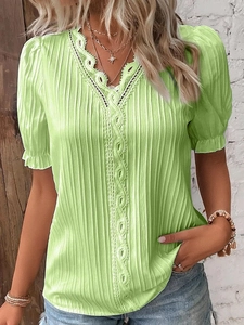 Detail of lime green V-neck top with white lace embroidery and vertical ribbed texture