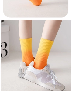Detail of ribbed knit crew socks featuring a gradient from yellow to vibrant orange