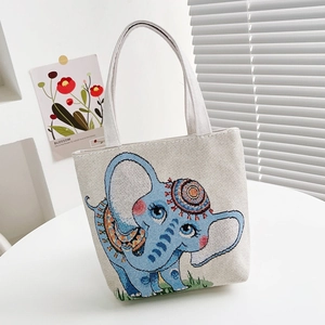 Close-up of cream canvas tote bag with a colorful ethnic elephant print and rope straps