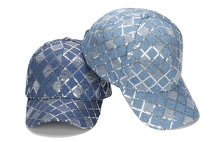 Detailed view of sequin embroidery on denim blue baseball caps with diamond grid pattern