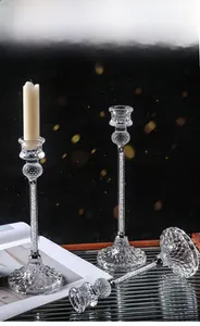 Close-up of diamond-filled glass candle holders on a wooden tray with a white candle