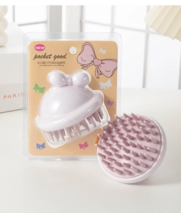 Detail of light purple scalp massager with bow design and soft silicone bristles