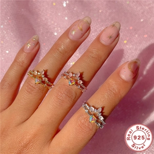 Adjustable S925 sterling silver rings with iridescent heart gems on pink fabric