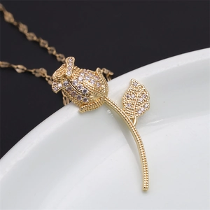 Macro shot of gold rose pendant with micro-pave zircons on a white ceramic plate