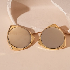 Detail of a geometric triangular gold stud earring with a matte taupe center inlay