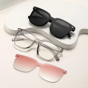 Flat lay of retro round sunglasses, transparent frames, and gradient lenses on a stone pedestal