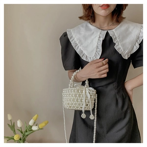 Détail d'un sac à perles avec noeud en soie et longue bandoulière en perles