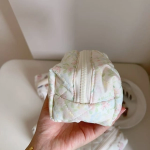 Close-up of floral quilted toiletry bag showing soft fabric texture and side profile