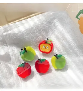 Detailed view of apple shaped hair claw clips in red and green glossy resin set