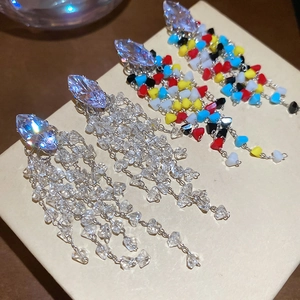 Detailed close-up of diamond-shaped crystal earrings with delicate fringe tassels
