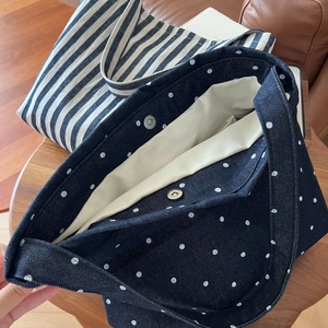 Close-up of denim tote bag with magnetic snap closure in polka dot and striped patterns
