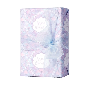 Pink mermaid scale gift wrapping paper with blue ribbon and Happy Birthday text