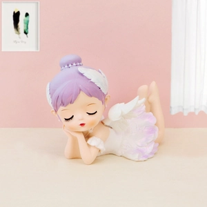 Detail of a resting angel girl statue with purple hair and white wings for cake decor