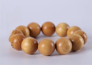 Macro detail of polished yellow boxwood beads showing natural wood grain and smooth finish