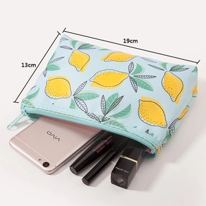 Detailed view of the 19x13cm light blue lemon print makeup bag with cosmetics